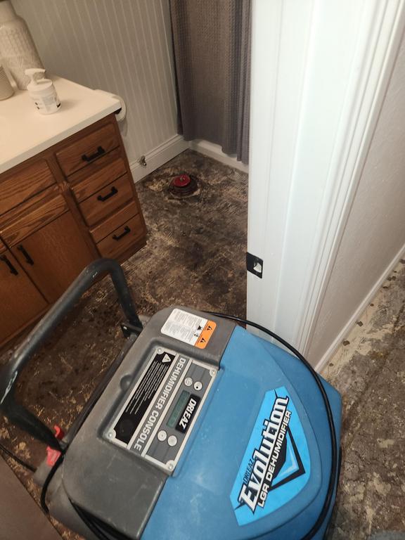 A blue machine is in the middle of a bathroom floor.