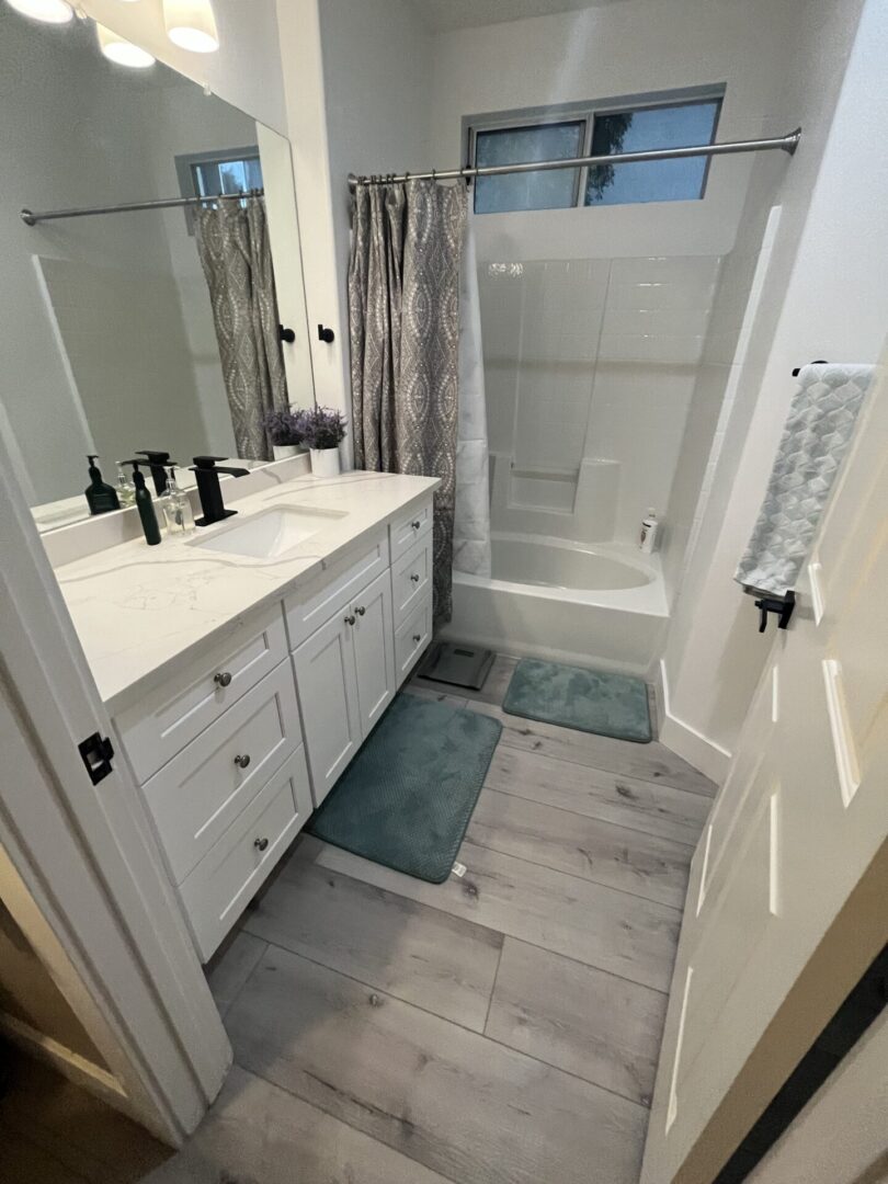 A bathroom with two sinks and a shower.