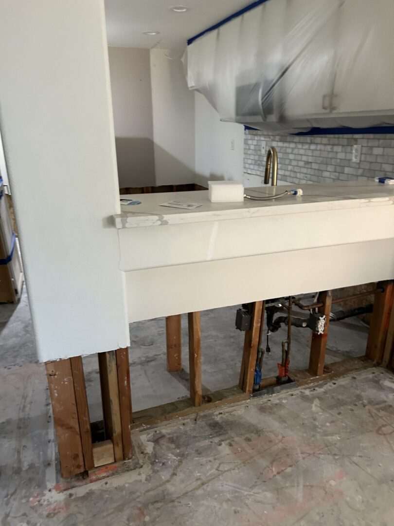 A kitchen being remodeled with the help of an old sink.